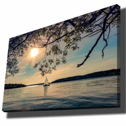 Lerretsbilde 70x100 cm - Seilbåt glir over en speilblank innsjø under en solrik himmel